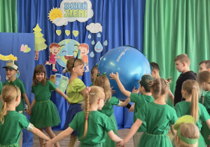 Dzieci trzymają w rękach model Ziemi.