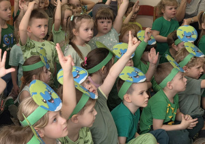 Dzieci podnoszą do góry ręce, żeby odpowiedzieć na zadane, tematyczne zagadki.
