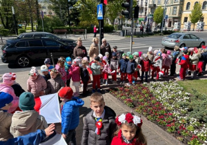 Korowód przedszkolaków pod pomnikiem.